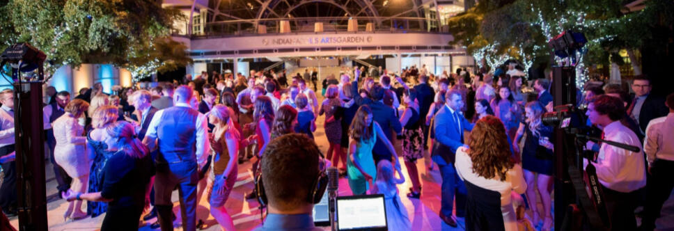 Packed Dance Floor at Indianapolis Artsgarden Packed dance floor at the Indianapolis Artsgarden with blue lighting; DJ booth and laptop in the foreground.